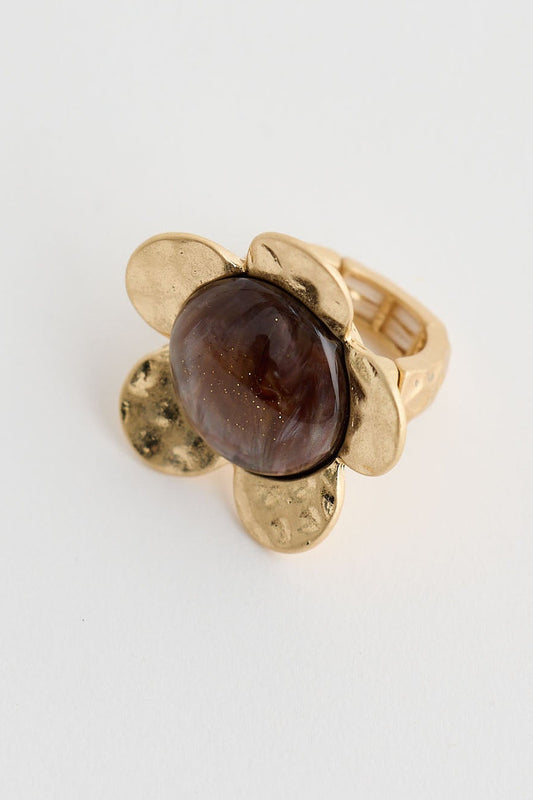 Gold ring with a brown gemstone on a white background