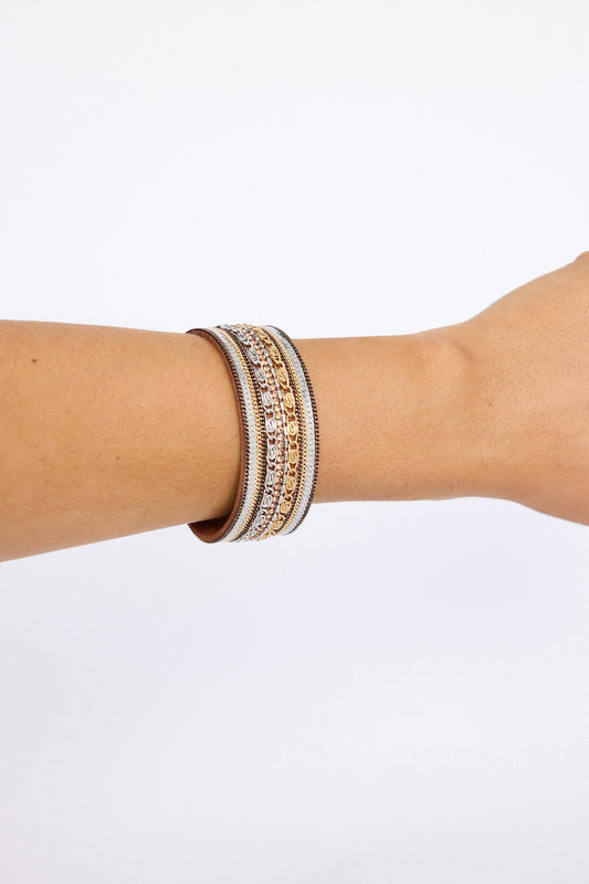 Model wearing Ballina Bracelet in brown with layered textures and embellished detailing, on-wrist view on neutral background