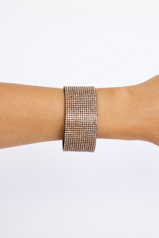 Model wearing Rover Bracelet in gold with layered textures and embellished detailing, on-wrist view on neutral background