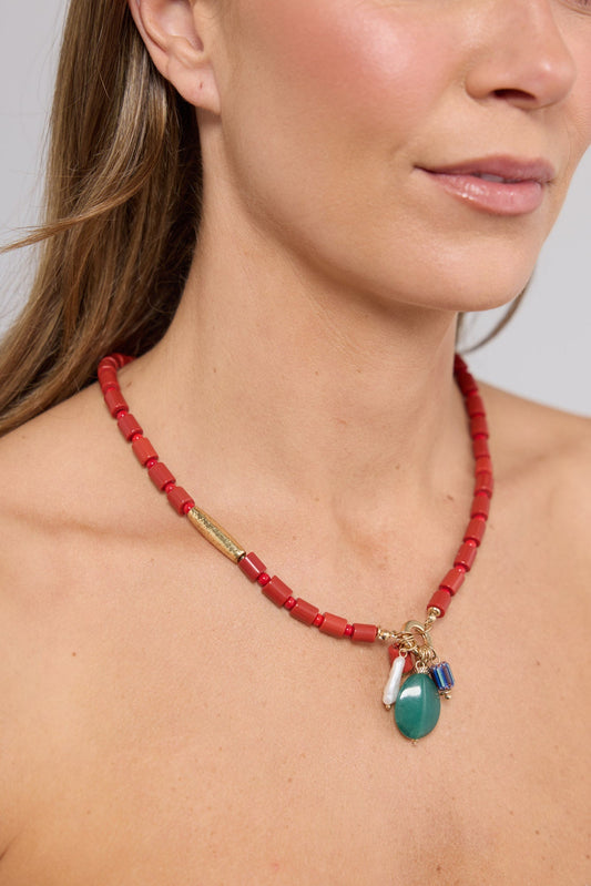 Close-up of the Elias Necklace in Aqua W Red worn at the neckline, showing the dangling charm cluster detail