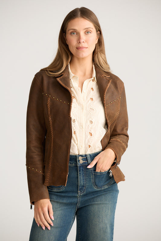 Woman wearing a brown leather jacket with studded details on a white background