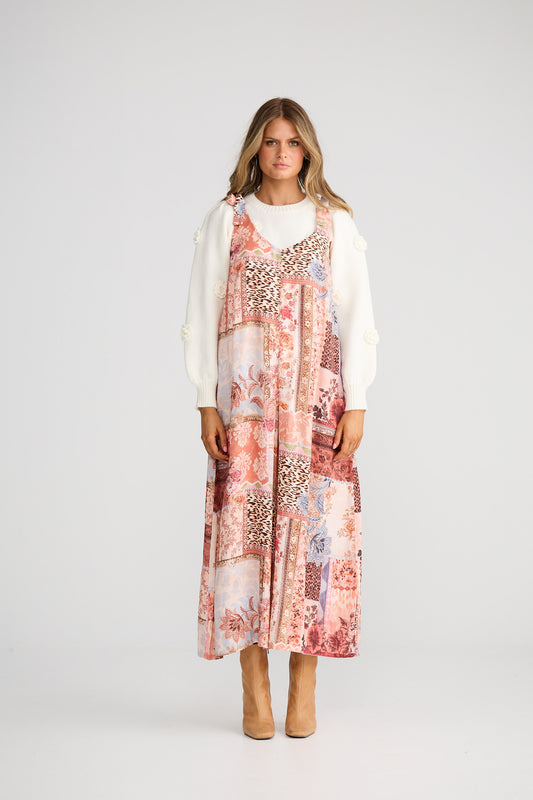 Woman wearing a floral dress with a white cardigan on a white background