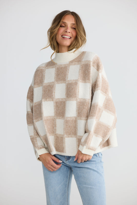 Model wearing Nyx Knit in oat and ivory with mock neck and dolman sleeve, front view on white background