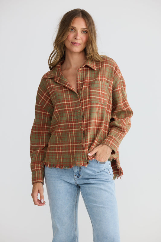 Model wearing Daytona Shirt in rust check with two-piece collar and long sleeves, side view on white background