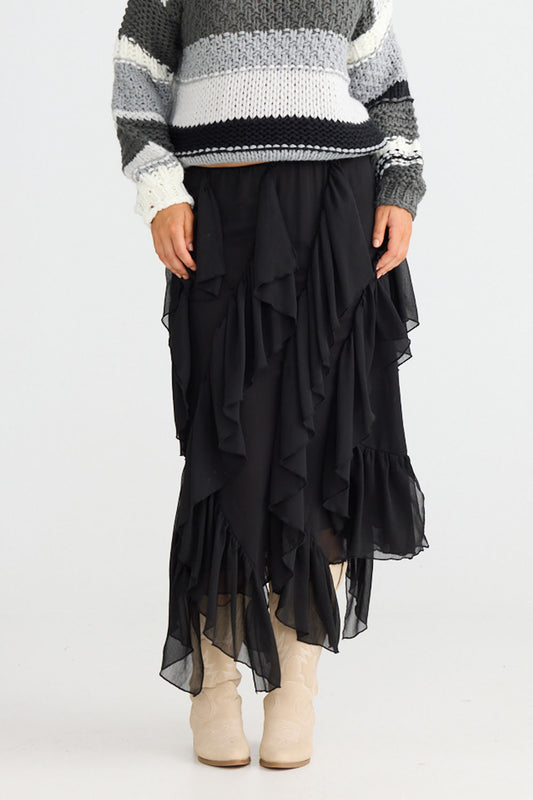 Model wearing Rafael Skirt in black with elasticated waist, side view on white background