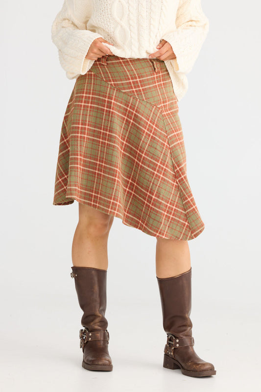 Model wearing Runa Skirt in rust check with natural waist fit, front view on white background
