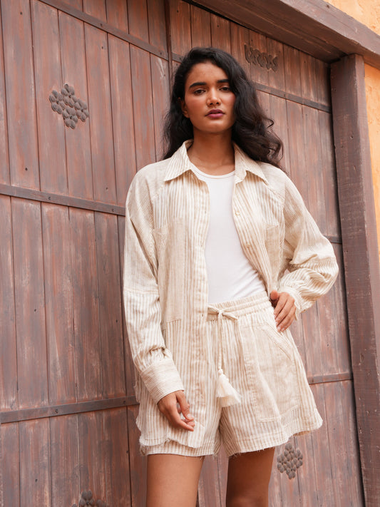 Bodhi Shirt in natural stripe worn open with the matching Bodhi Short, full length against a timber door.