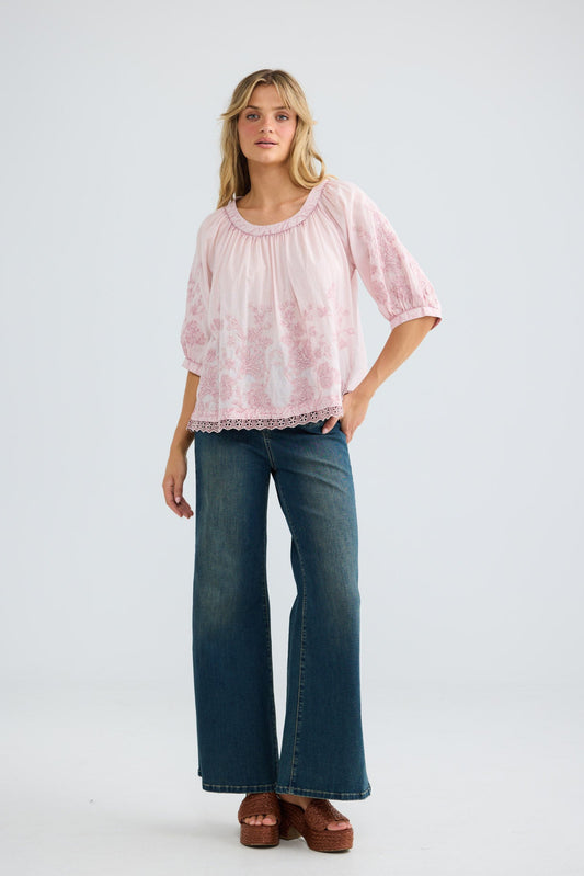 Model wearing Thistle Top in soft pink, front view.