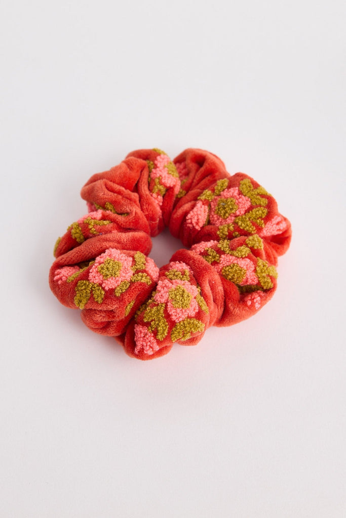 Red scrunchie with floral patterns on a white background
