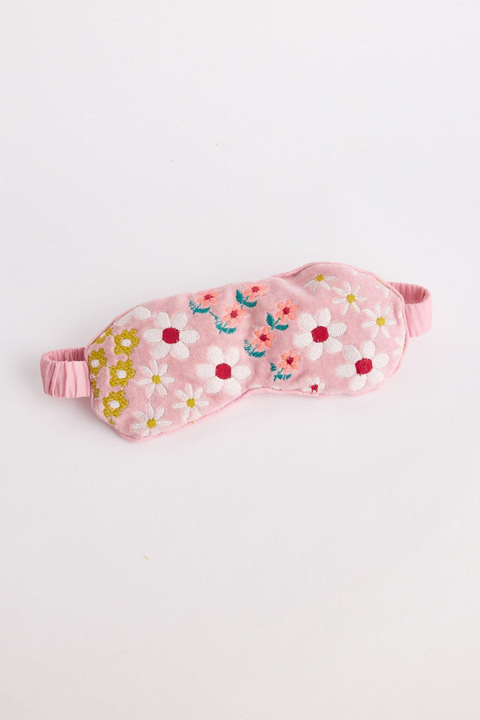 Pink sleep mask with floral pattern on a light gray background