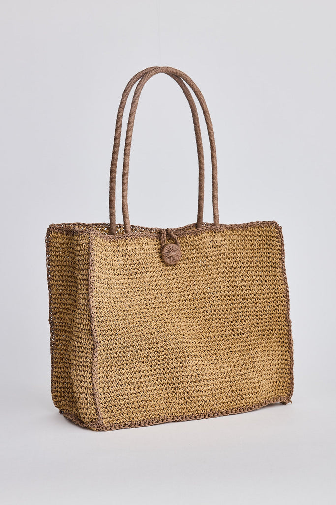 Woven straw tote bag with brown handles on a light gray background