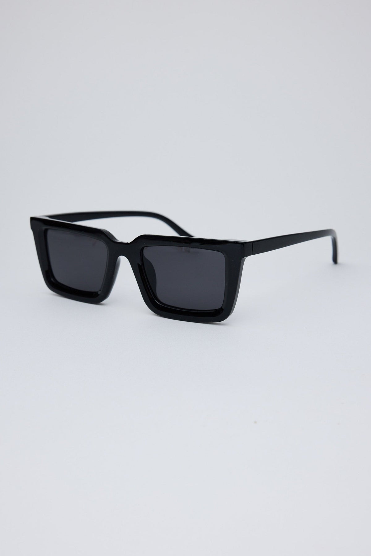 Angled view of Black Coastline Sunglasses on white background