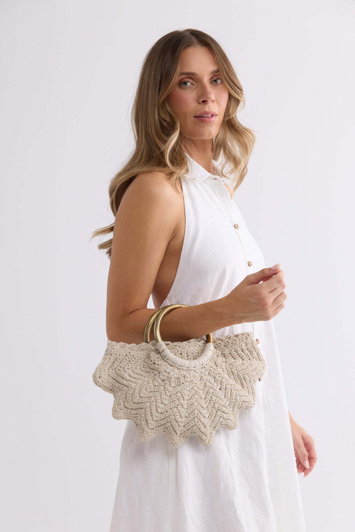 Santana Bag in off white held up, close view styled with a white button-front shirt dress