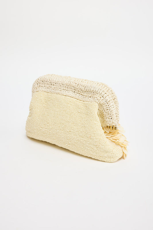 Sandy Clutch in creme - three-quarter angle showing the dimensional shell fringe and gold-tone frame clasp