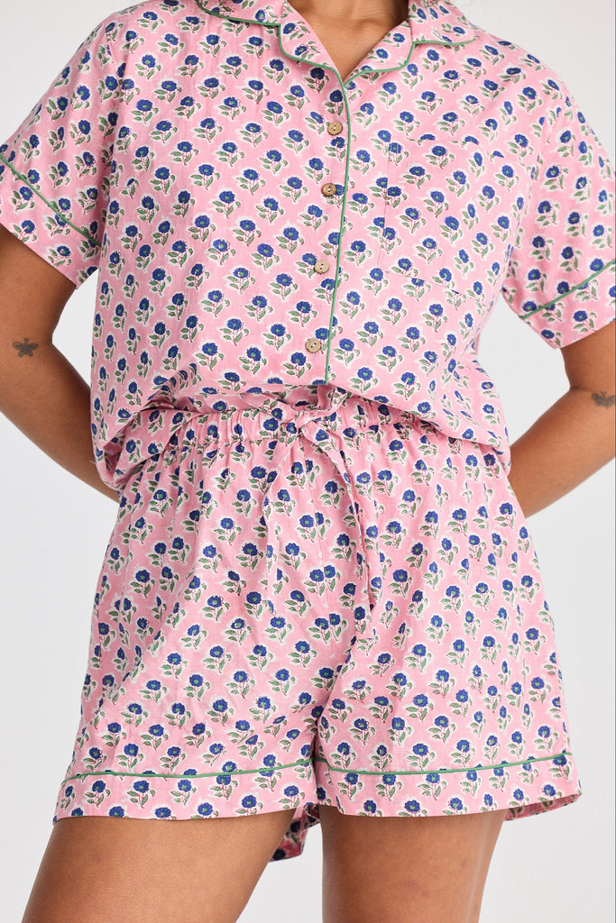 Person wearing a pink floral pyjama set on a plain background