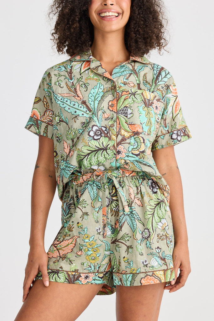 Woman wearing a floral patterned pyjama set on a white background
