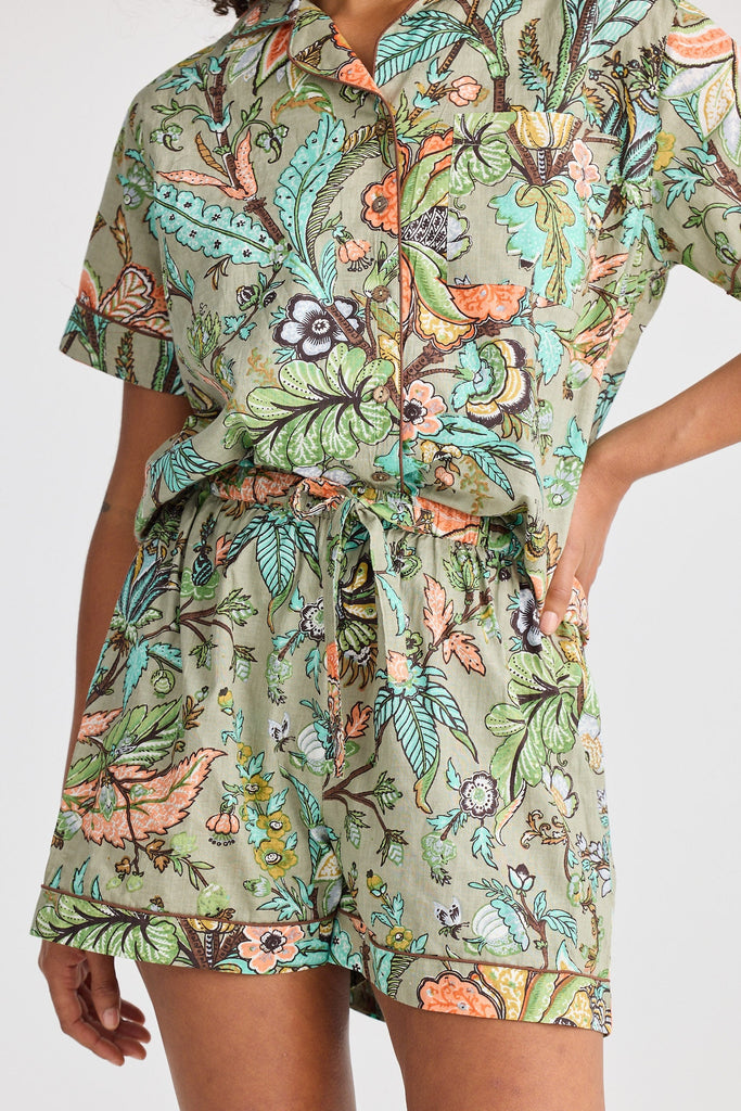 Person wearing a floral patterned pyjama set on a white background