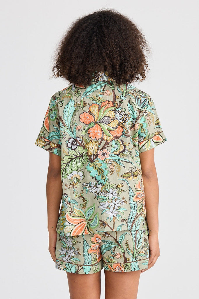 Person wearing a floral pajama set on a white background