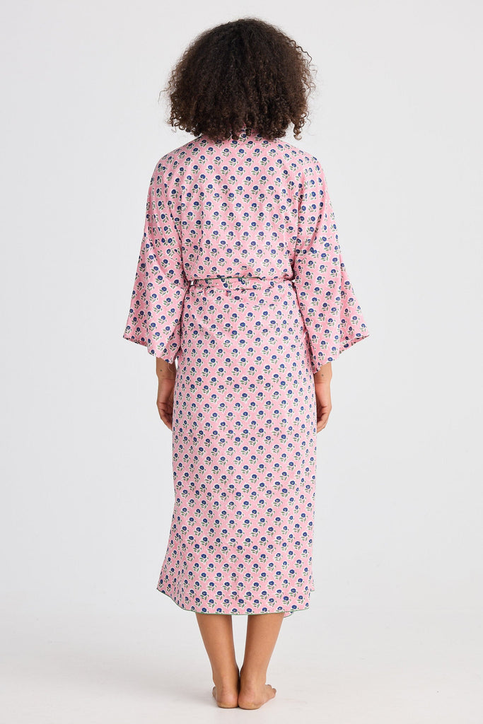 Woman wearing a pink patterned robe on a white background