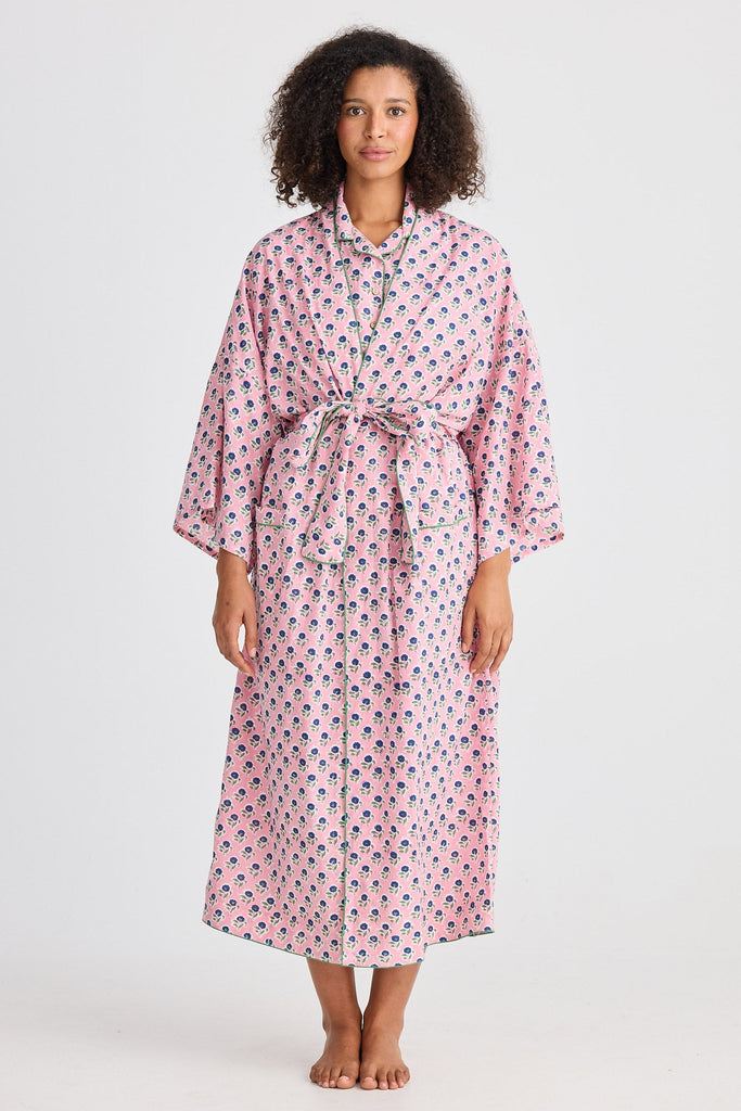 Woman wearing a pink floral robe on a white background