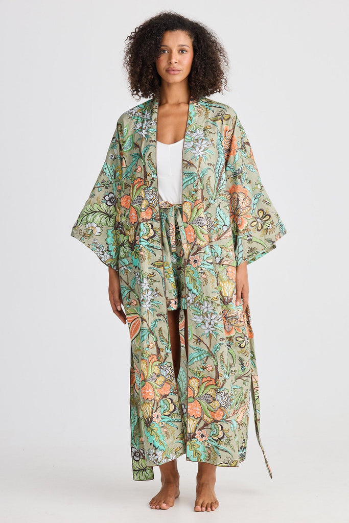 Woman wearing a floral kimono-style robe on a white background