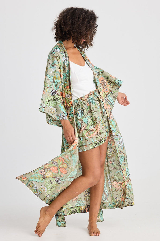 Woman wearing a floral kimono-style robe on a white background
