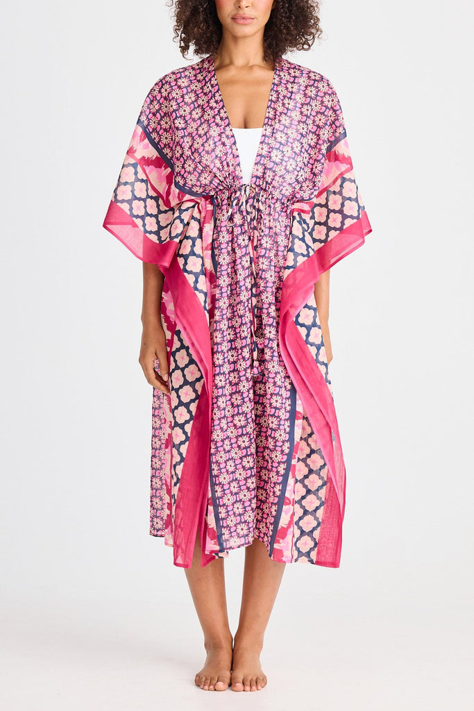 Woman wearing a pink and purple patterned kimono-style garment on a white background