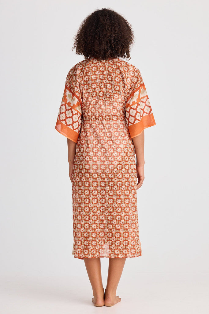 Woman wearing a patterned kaftan on a white background