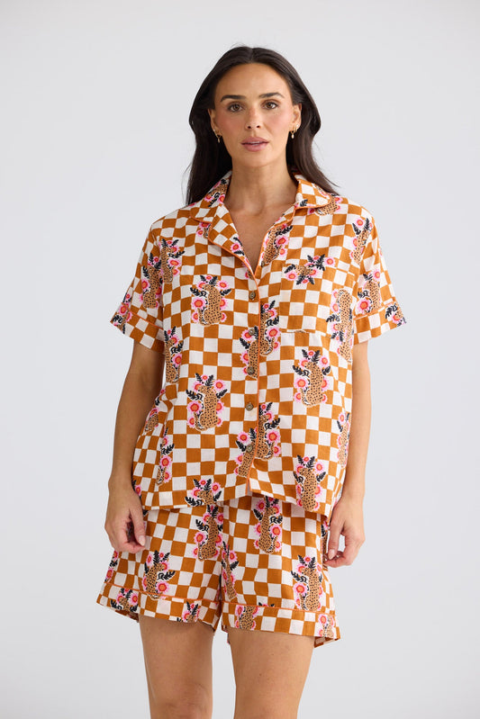 Model wearing Namaste Pyjama Set in tiger check, front view. Short-sleeve shirt with piping and matching shorts.