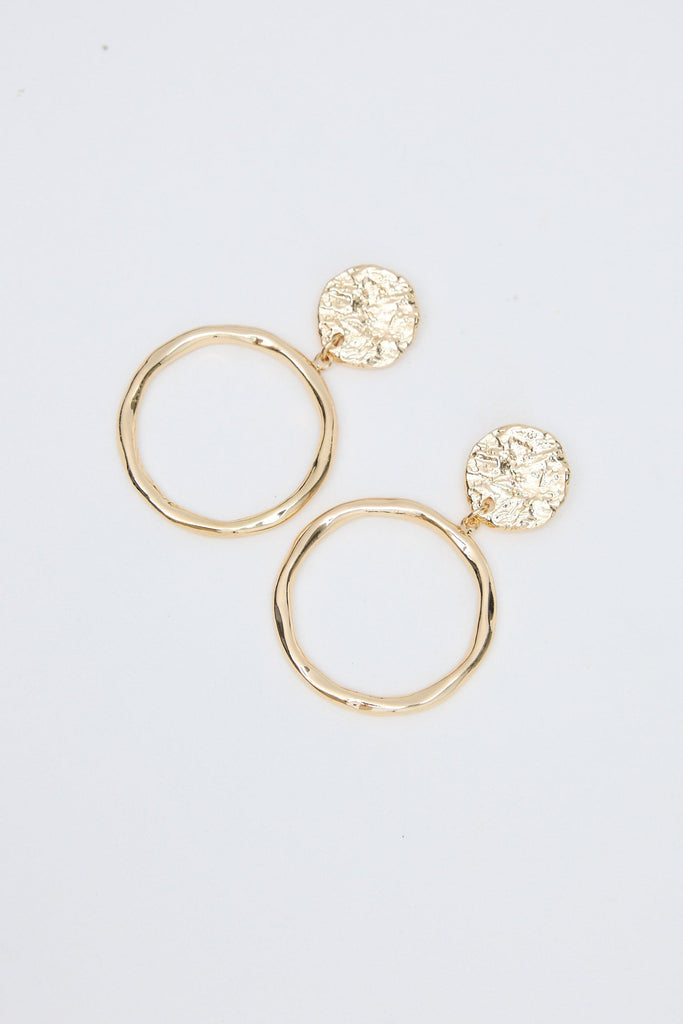 Gold hoop earrings with round embellishments on a light gray background