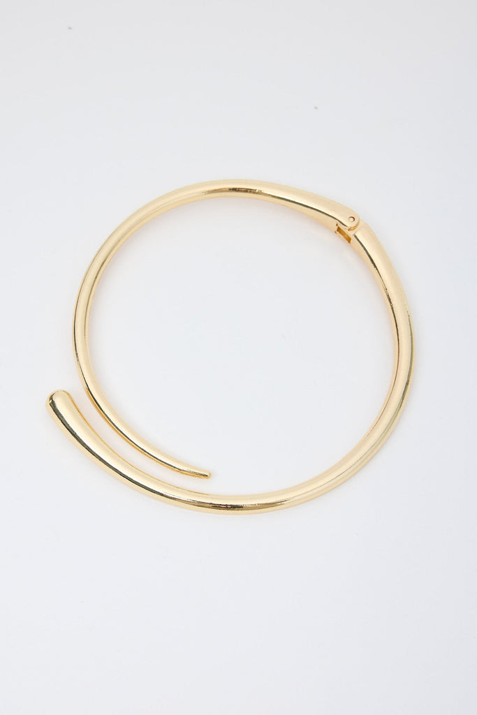 Gold necklace on a light gray background