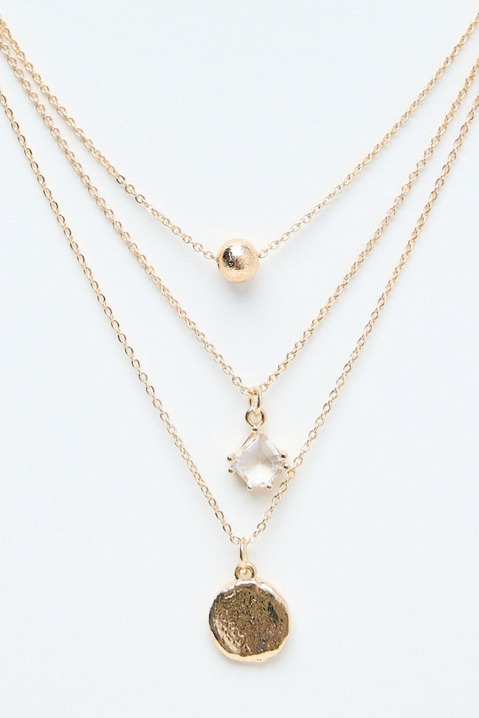 Gold necklaces on a mannequin with a white background