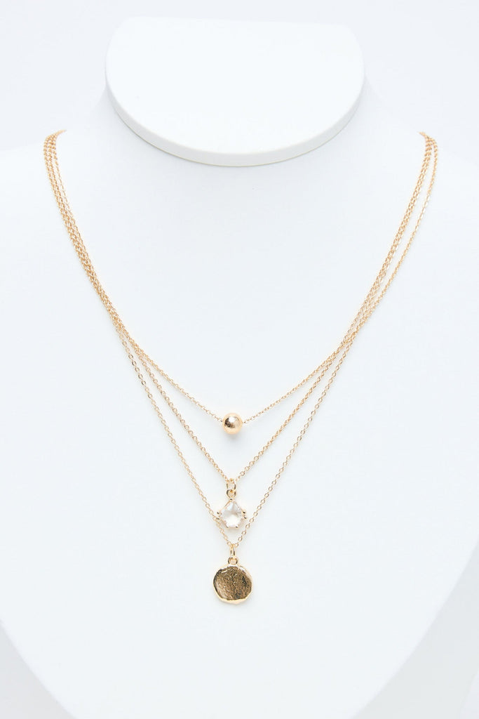 Gold necklaces on a mannequin with a white background