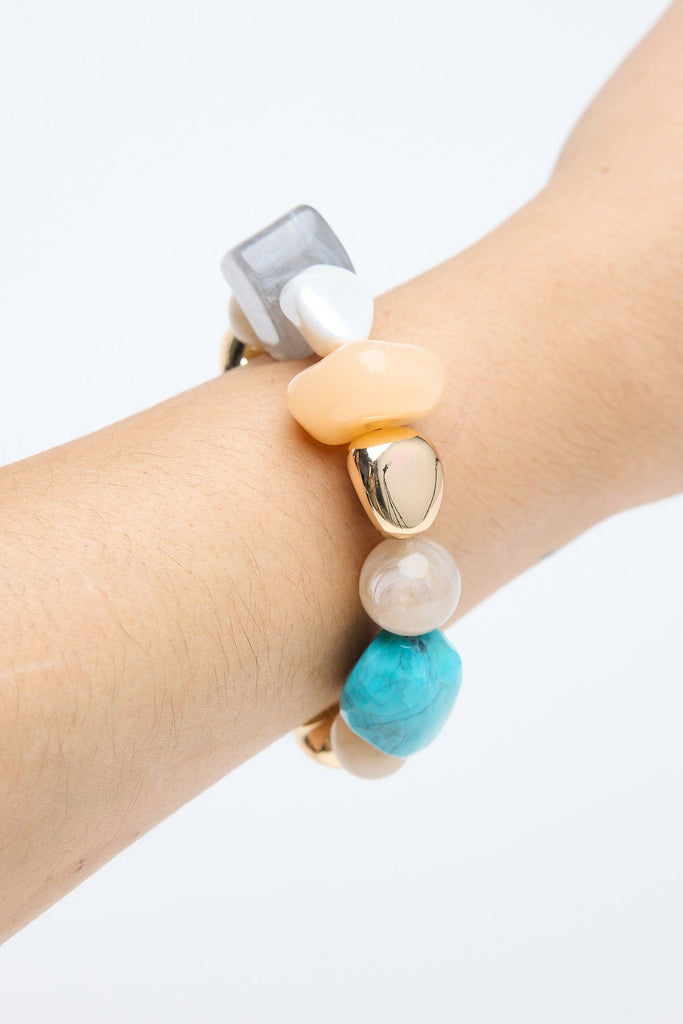 Bracelet with colorful beads on a wrist against a light background