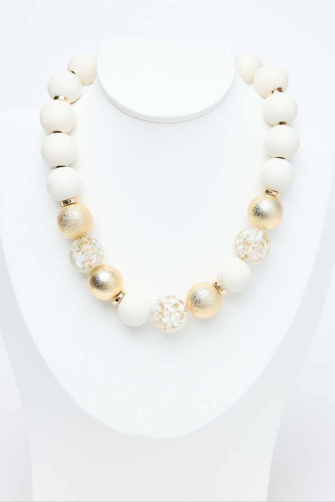 Necklace with white and gold beads on a white background