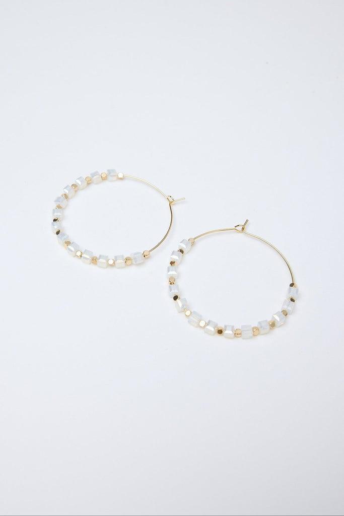 Pair of hoop earrings with pearl-like beads on a white background