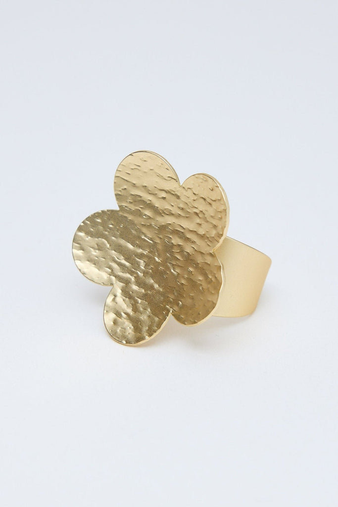 Gold flower ring on a light gray background