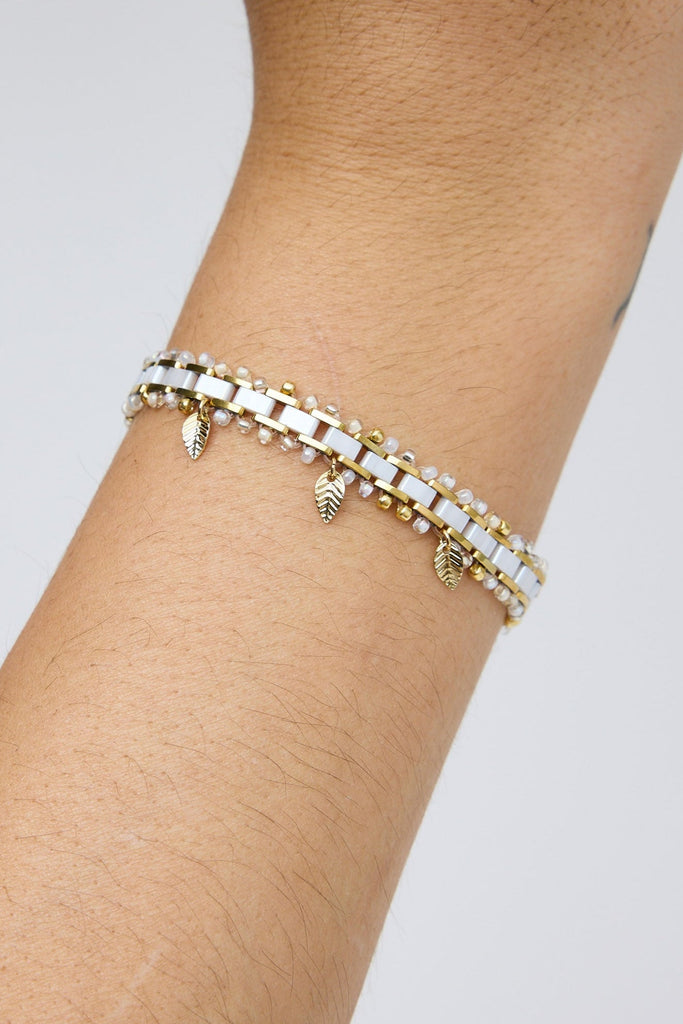 Bracelet on a wrist with a plain background