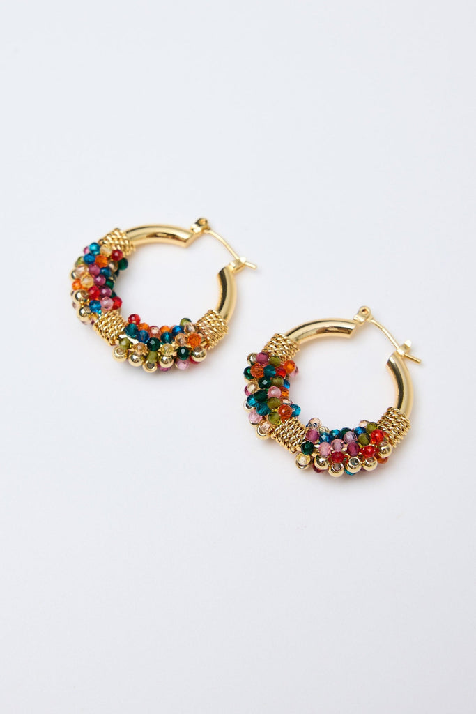 Gold hoop earrings with colorful beads on a white background