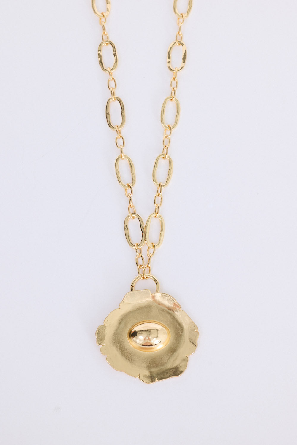 Flora Necklace in gold with sculptural floral pendant detail, front view on white background