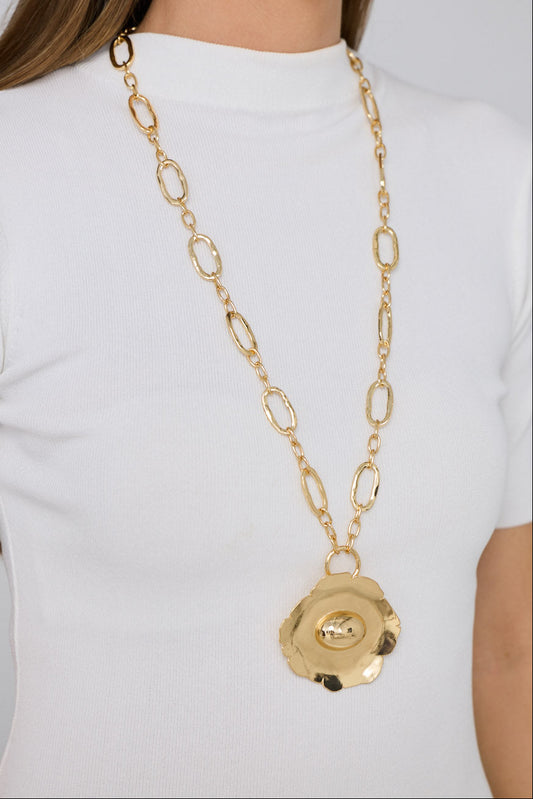Flora Necklace in gold with sculptural floral pendant detail, neckline styled view on neutral background