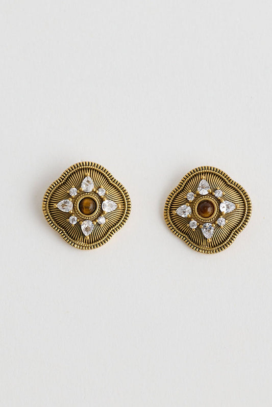 Pair of gold hexagonal earrings on a light gray background