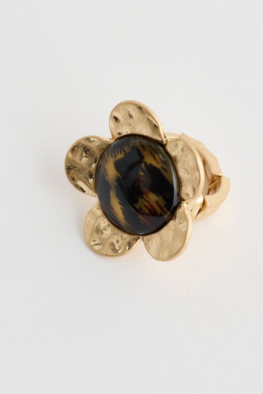 Gold earring with a dark gemstone on a white background