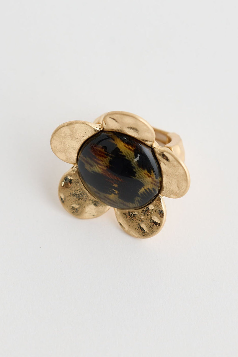 Gold earring with a dark gemstone on a light gray background