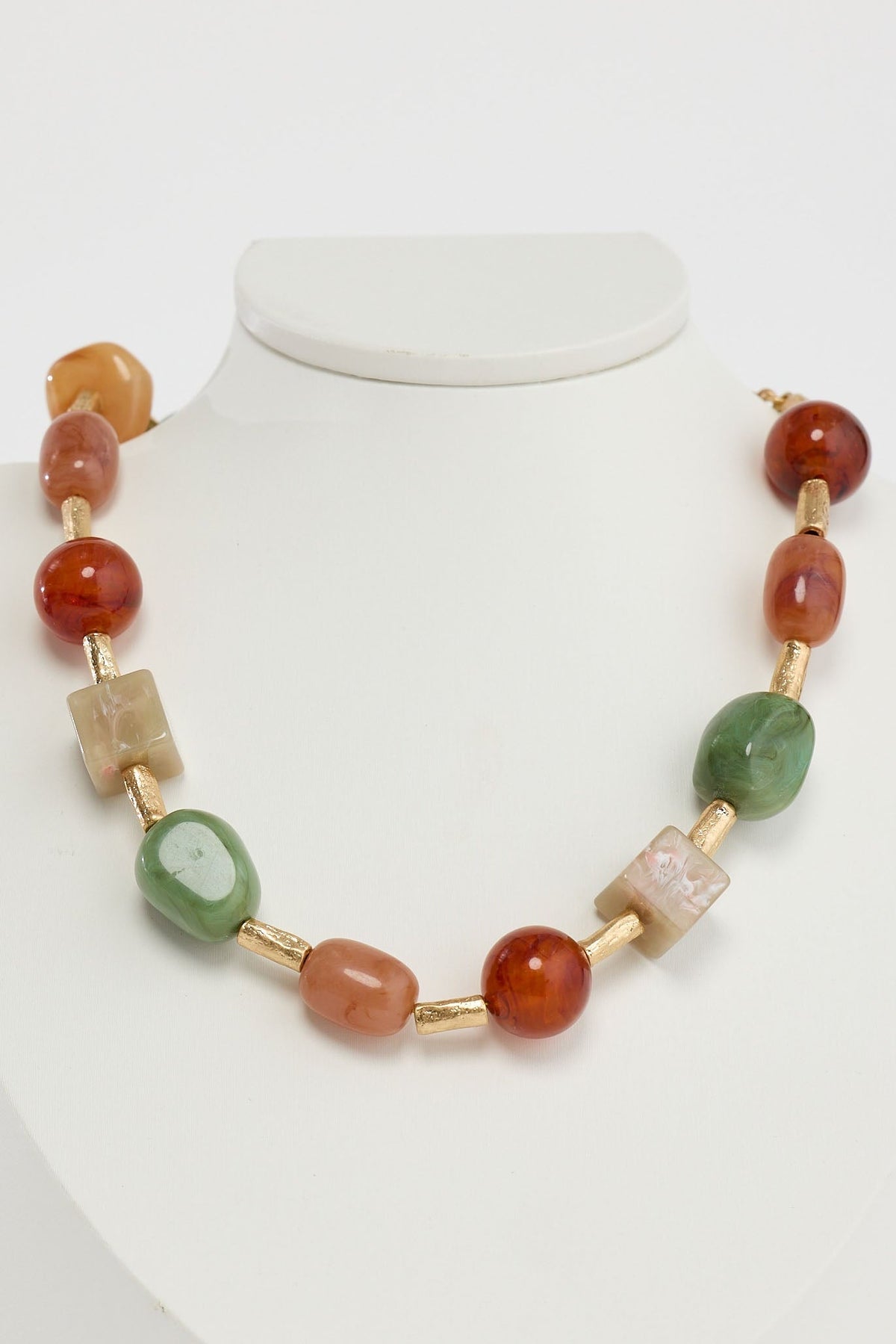 Necklace with multicolored beads on a mannequin against a white background
