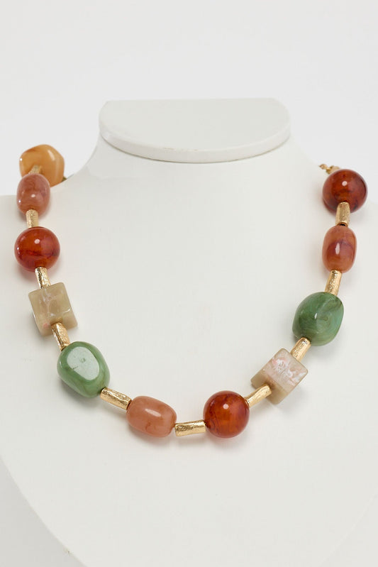 Necklace with multicolored beads on a mannequin against a white background