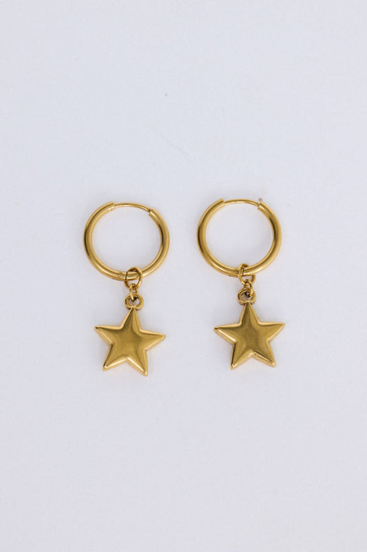 Star Gaze Earrings in gold with bold star charm detail, angled view on white background