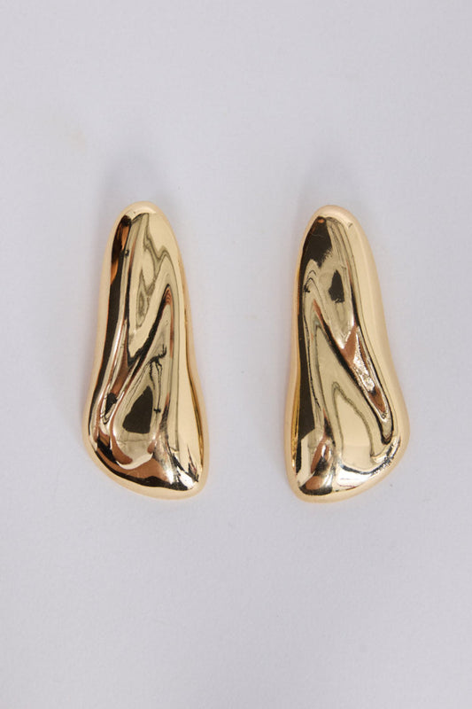 Gold earrings on a light gray background
