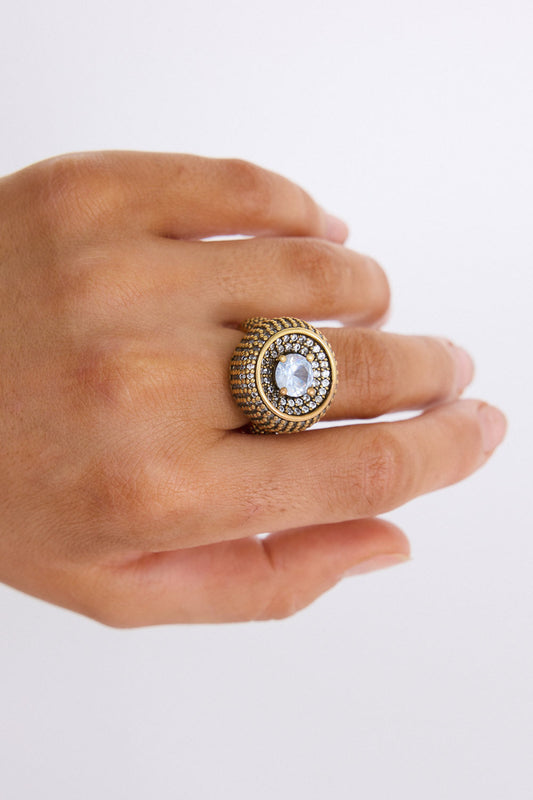 Model wearing Halo Ring in gold with central stone and textured band detailing, ring styling view on neutral background