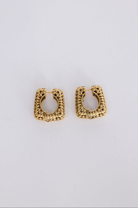 Paloma Earrings in gold with textured finish, angled view on white background